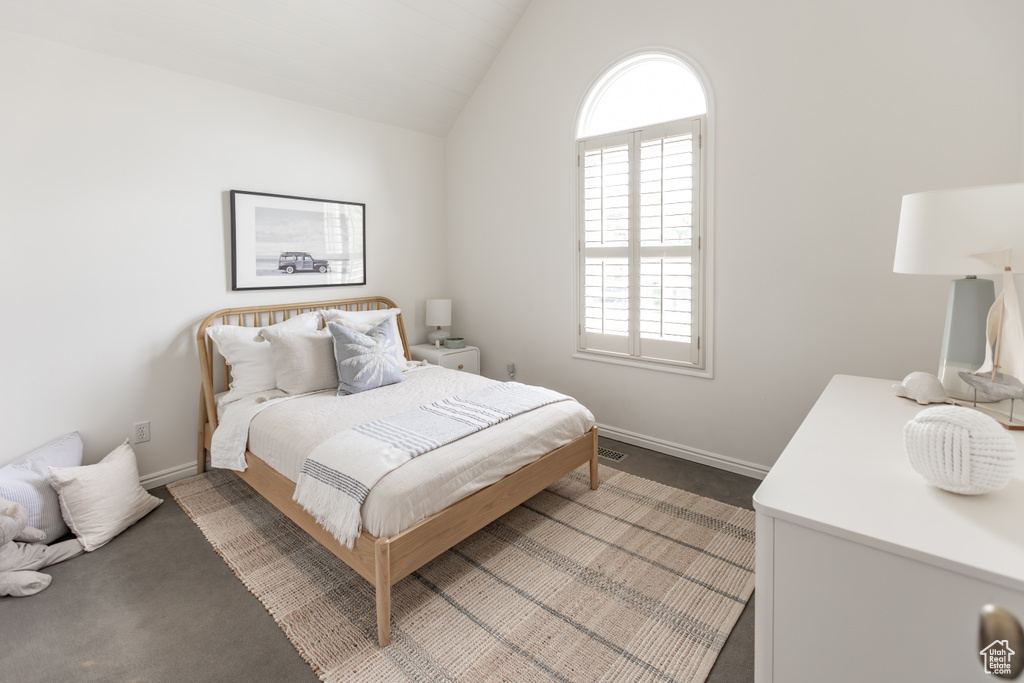 Bedroom with lofted ceiling and carpet floors