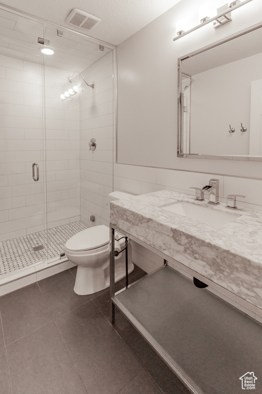 Bathroom with a shower stall, vanity, and tile patterned flooring