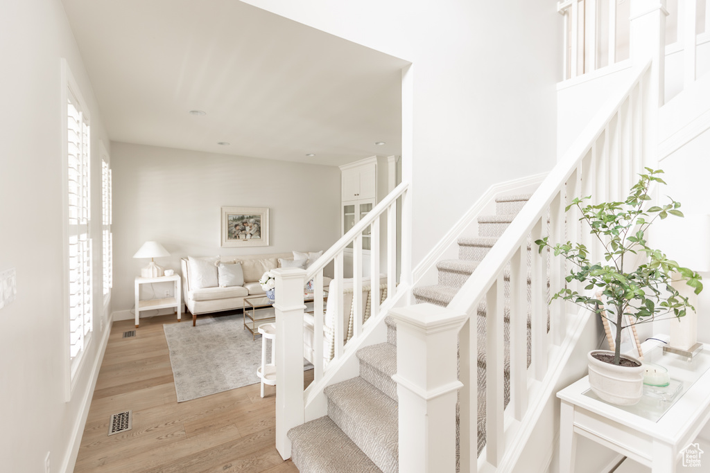Stairway with wood finished floors and baseboards