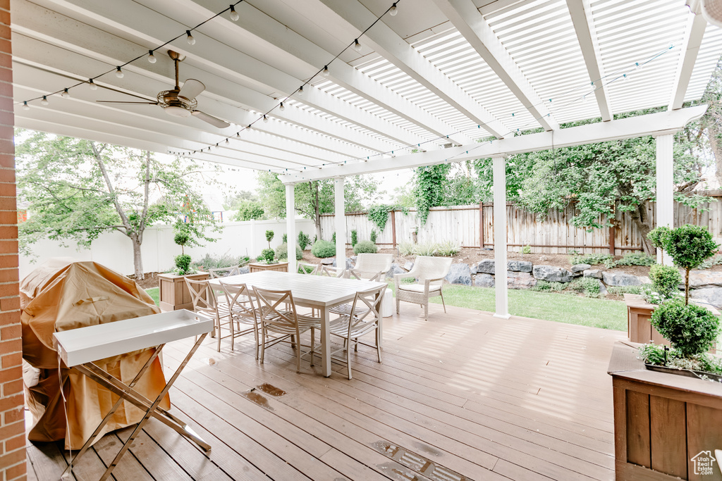 Wooden terrace featuring outdoor dining area and a fenced backyard
