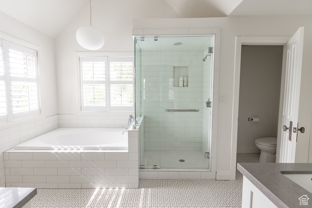 Bathroom with tile patterned flooring, a stall shower, vanity, a bath, and vaulted ceiling