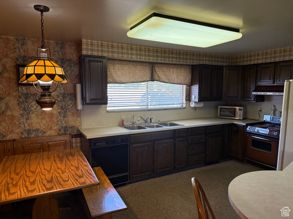 Kitchen featuring stove, black dishwasher, under cabinet range hood, stainless steel microwave, and light countertops