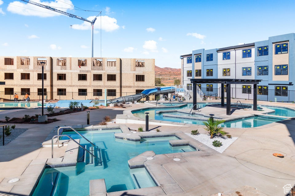 Community pool featuring a community hot tub, a patio area, and a pergola
