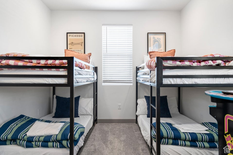 Carpeted bedroom featuring multiple windows