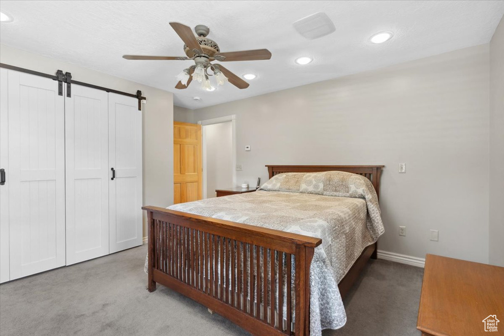 Bedroom featuring carpet floors, recessed lighting, a closet, a ceiling fan, and a barn door