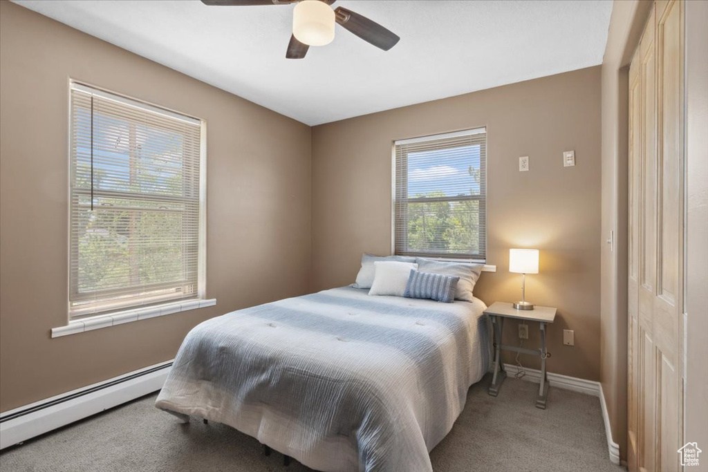 Bedroom featuring baseboard heating, carpet floors, and ceiling fan