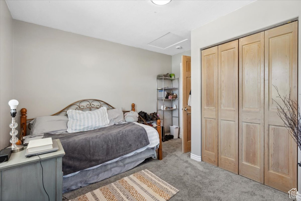 Carpeted bedroom featuring attic access and a closet