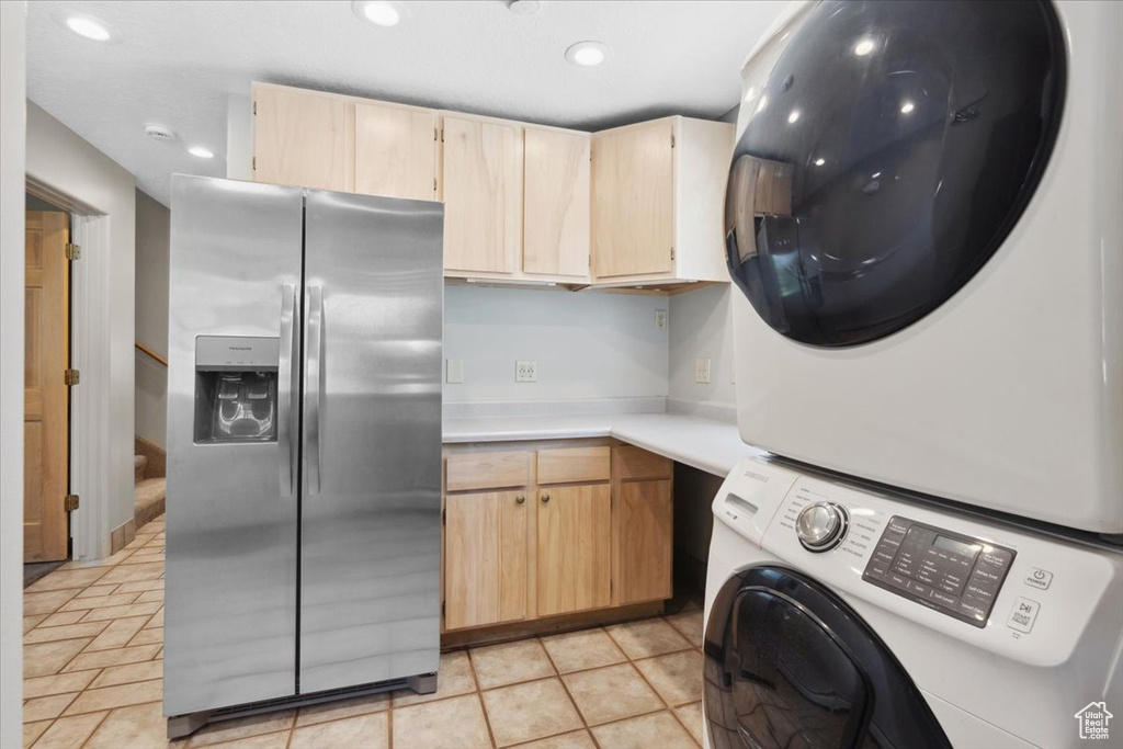 Laundry room featuring stacked washer / dryer and recessed lighting