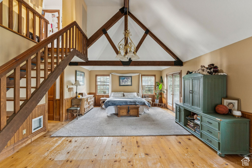 Bedroom with light wood-style flooring and high vaulted ceiling
