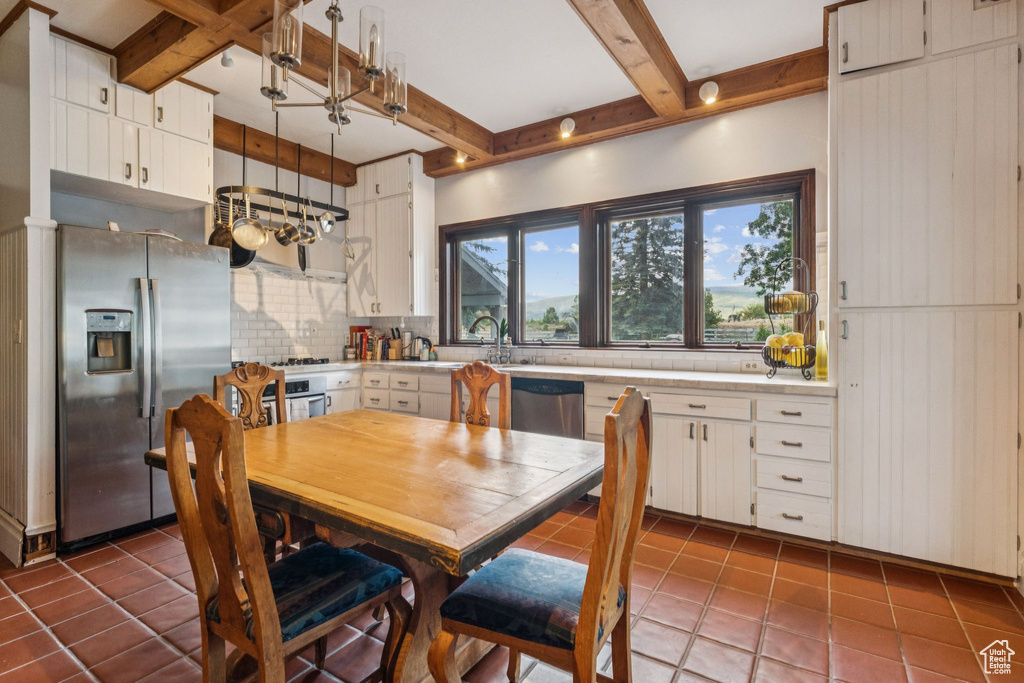 Dining area featuring beamed ceiling and tile patterned flooring