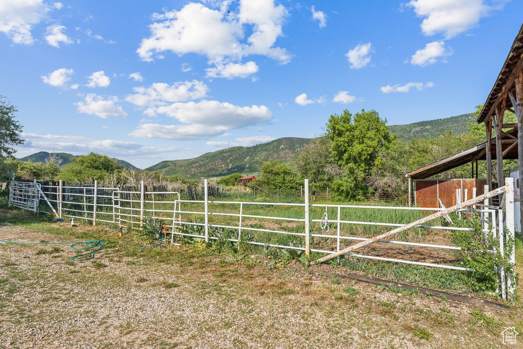 View of yard with a mountain view, an exterior structure, and a view of rural / pastoral area