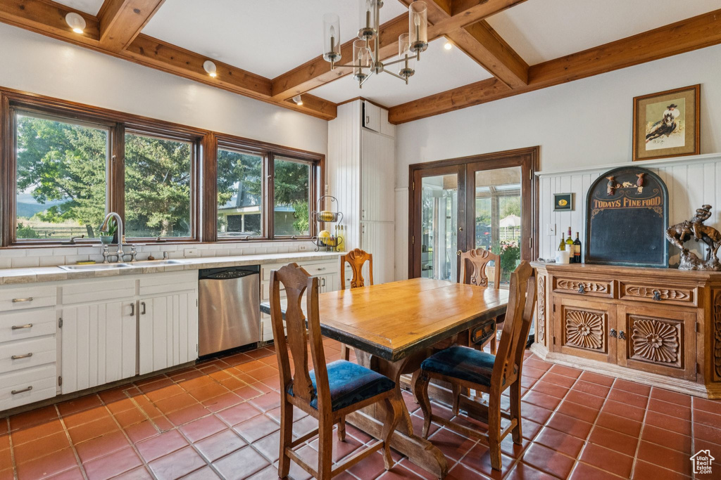 Dining room with coffered ceiling, beam ceiling, tile patterned floors, and french doors