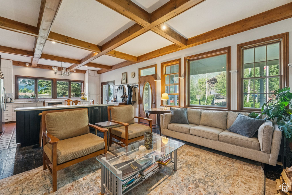 Living room featuring coffered ceiling, beamed ceiling, and dark wood finished floors