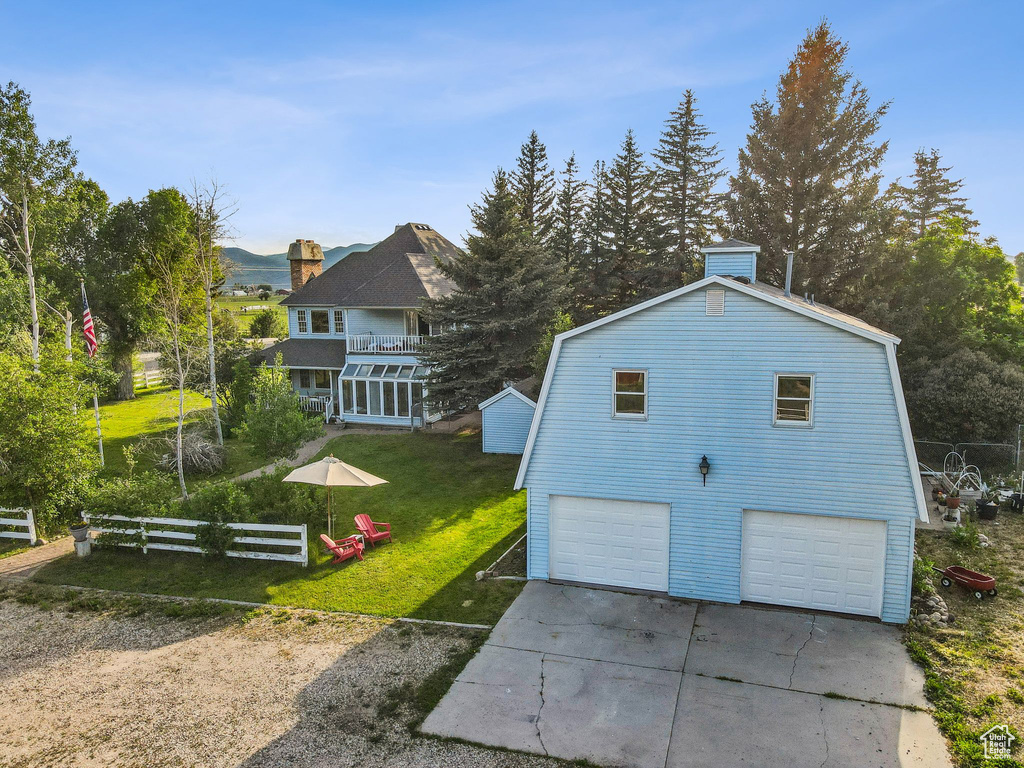 View of side of property with driveway and a gambrel roof