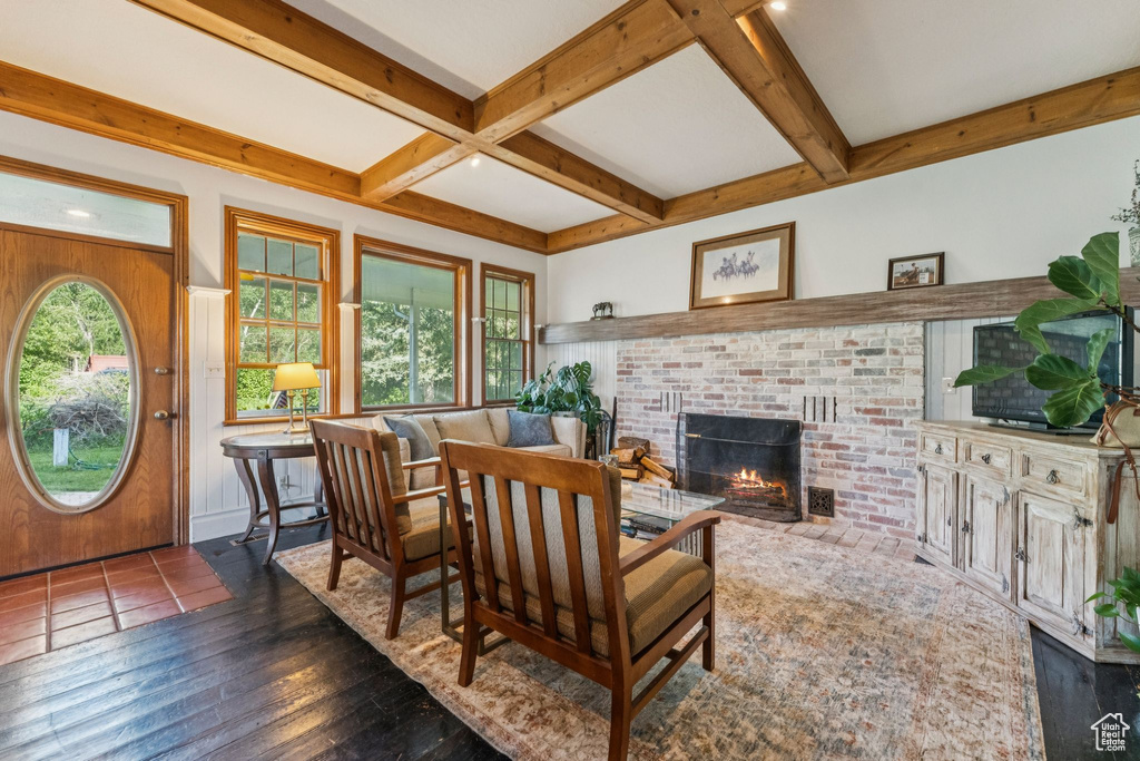 Living room featuring a fireplace, beamed ceiling, coffered ceiling, and dark wood finished floors
