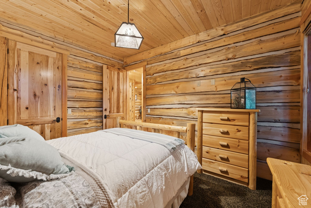 Bedroom featuring dark colored carpet and wooden ceiling