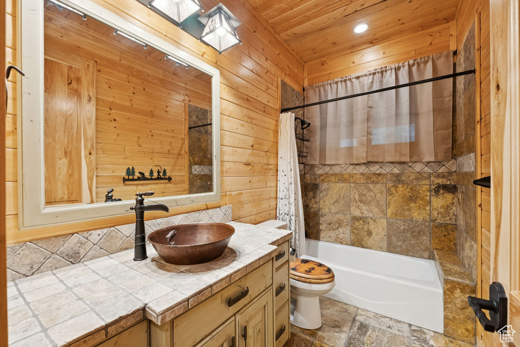 Full bathroom featuring vanity, wood ceiling, backsplash, shower / tub combo, and wood walls