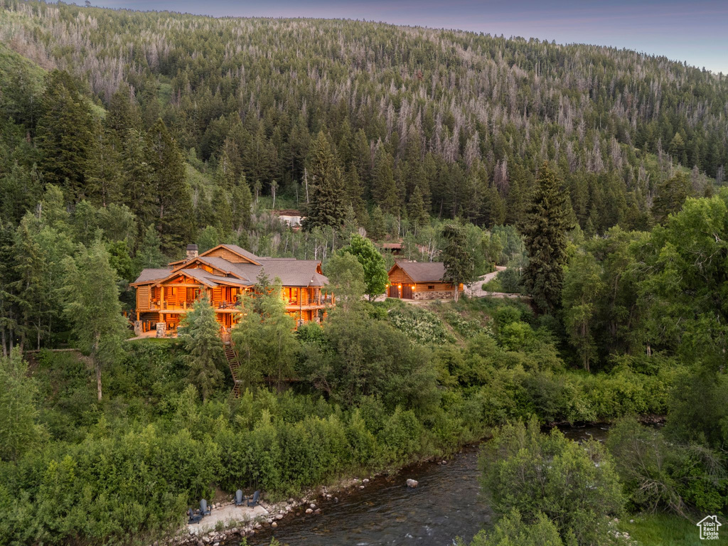 Aerial view of property and surrounding area with a heavily wooded area