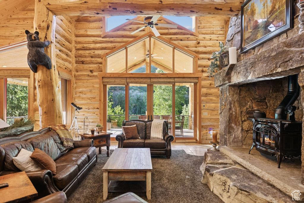 Living room with log walls, high vaulted ceiling, a wood stove, and beamed ceiling