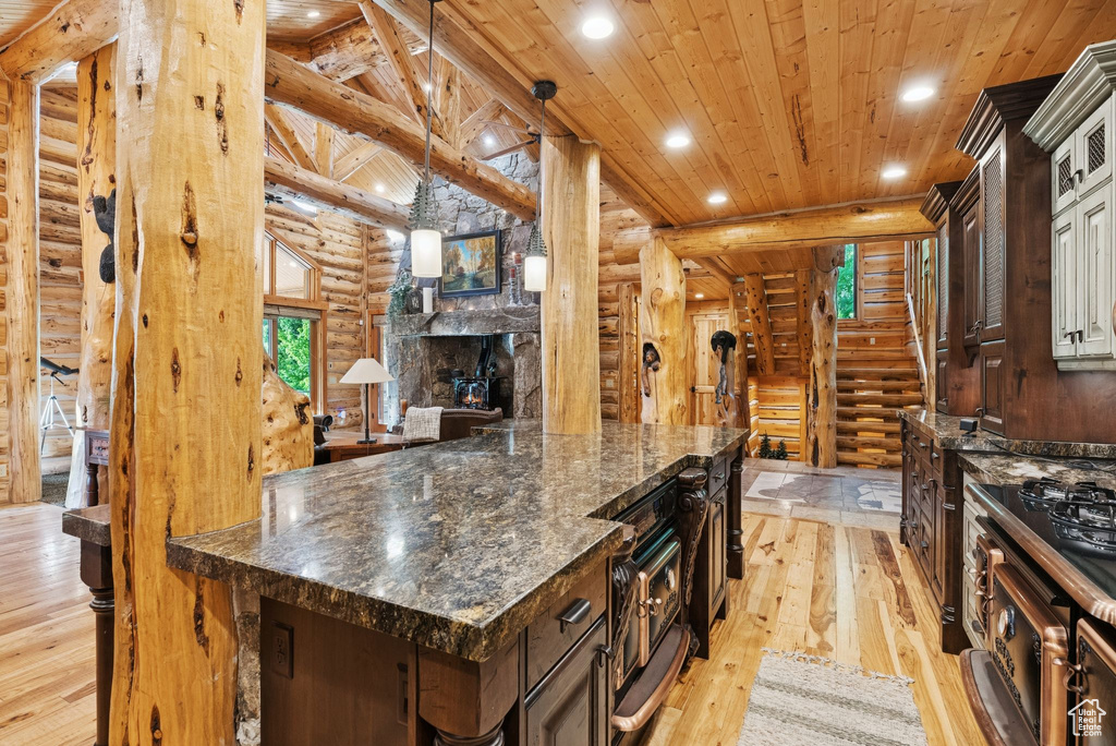 Kitchen featuring log walls, wooden ceiling, light wood-style flooring, recessed lighting, and dark brown cabinetry