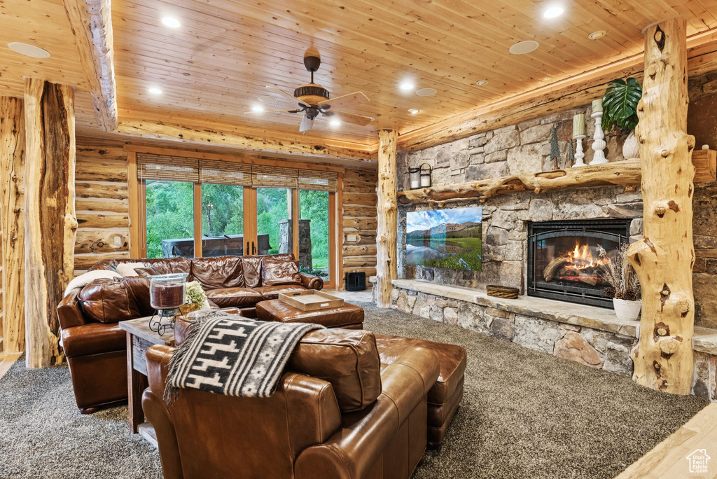 Living room featuring wood ceiling, log walls, a fireplace, ceiling fan, and recessed lighting