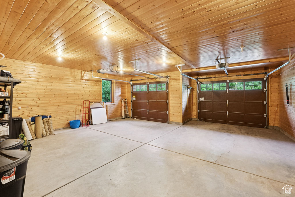Garage with wooden walls and a garage door opener
