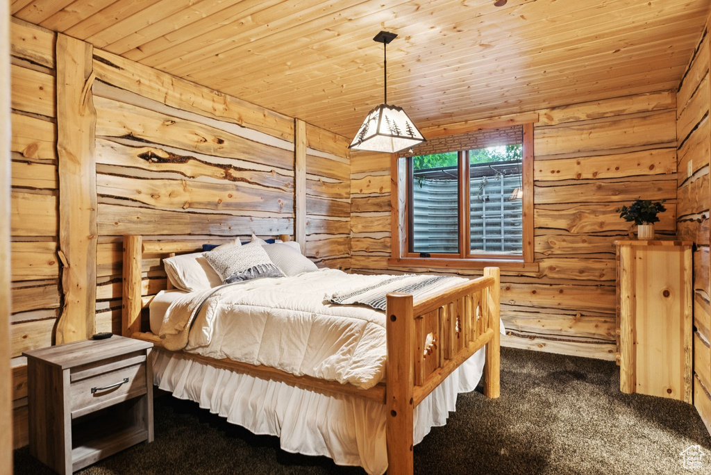 Carpeted bedroom with wood walls and wood ceiling