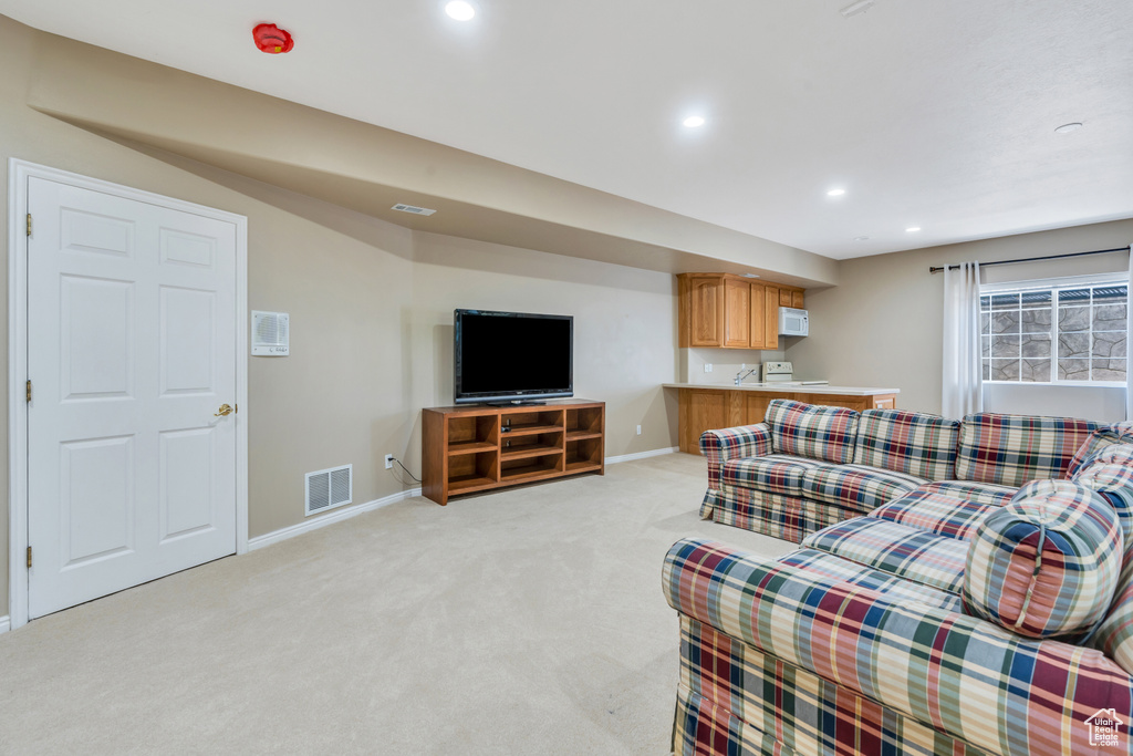Living area featuring light colored carpet and recessed lighting