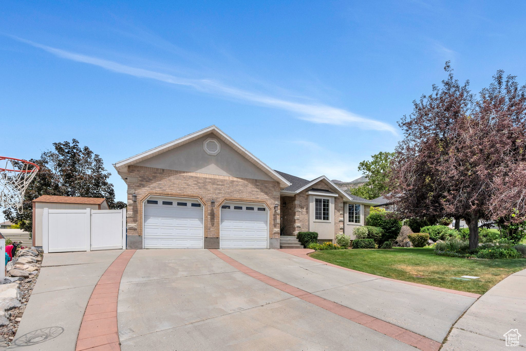 Ranch-style home with brick siding, driveway, and an attached garage