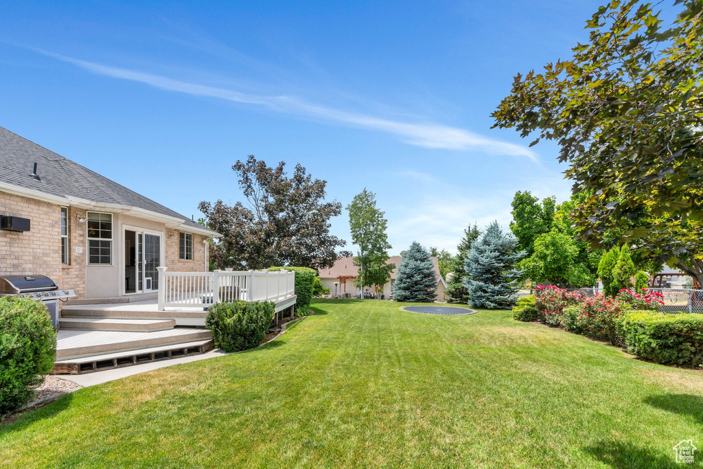 View of green lawn featuring a deck