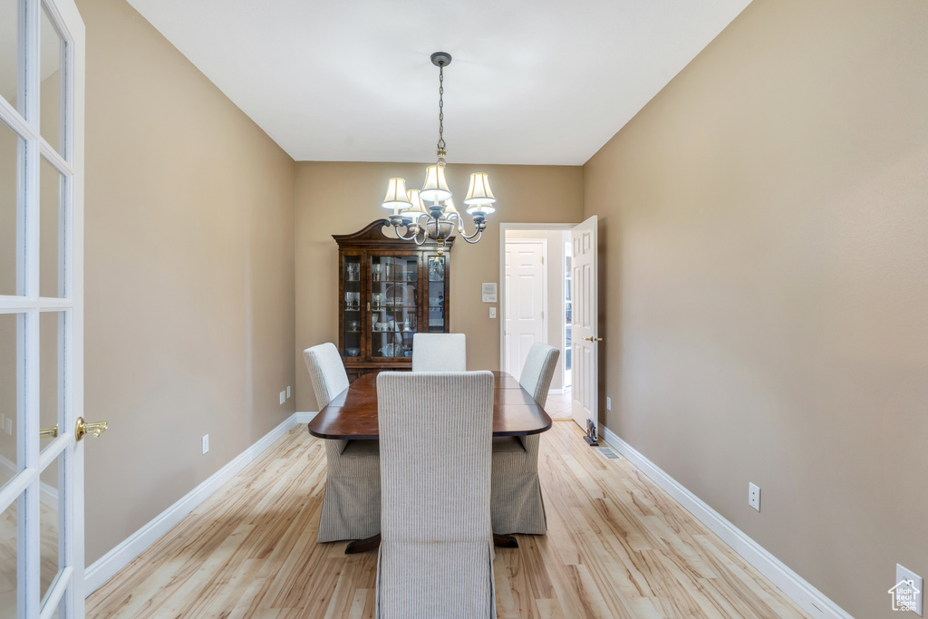Dining space featuring a chandelier, light wood-type flooring, and french doors