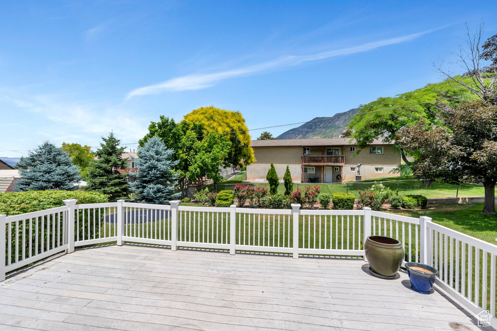 Wooden deck with a lawn and a mountain view