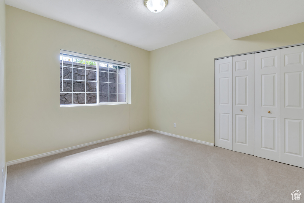 Unfurnished bedroom with carpet flooring and a closet