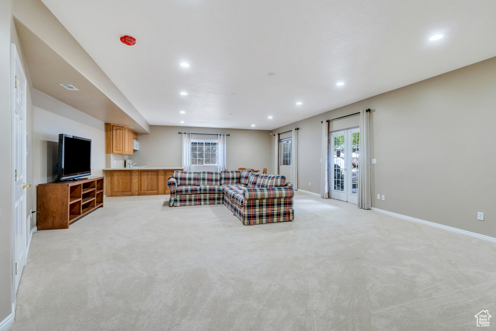 Living area with recessed lighting and light carpet