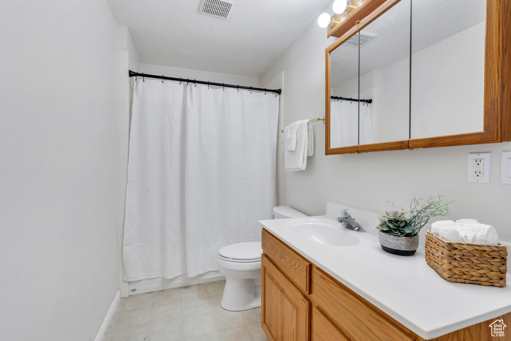 Bathroom with vanity, tile patterned floors, and curtained shower