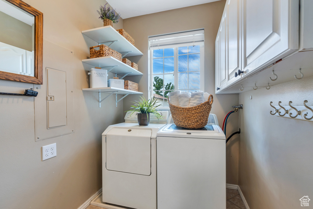 Laundry area with cabinet space, washer and dryer, electric panel, and tile patterned flooring