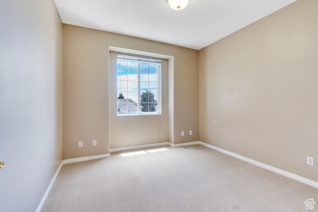 Carpeted empty room with baseboards