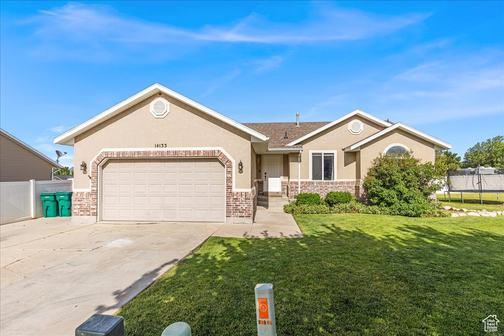 Ranch-style house with stucco siding, concrete driveway, a garage, and brick siding