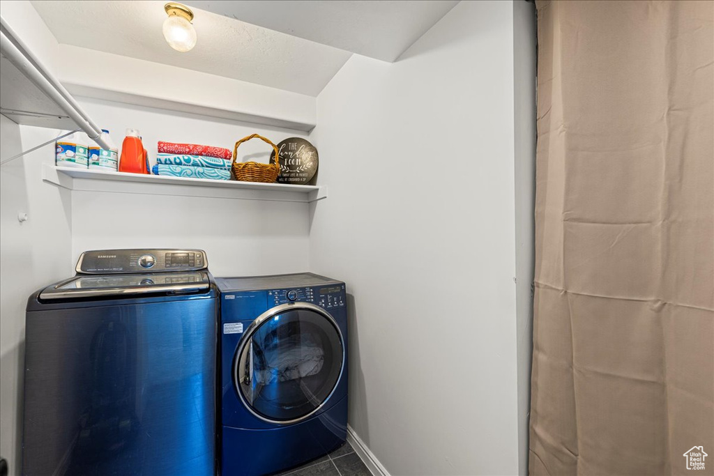 Laundry area featuring separate washer and dryer and baseboards