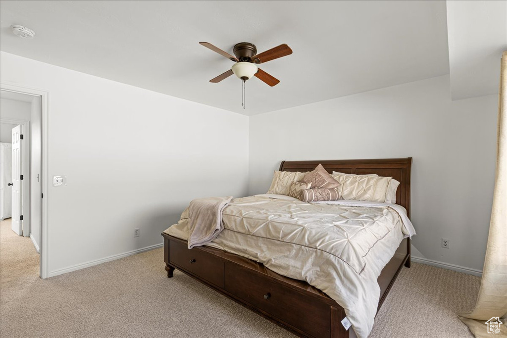 Carpeted bedroom featuring baseboards and a ceiling fan