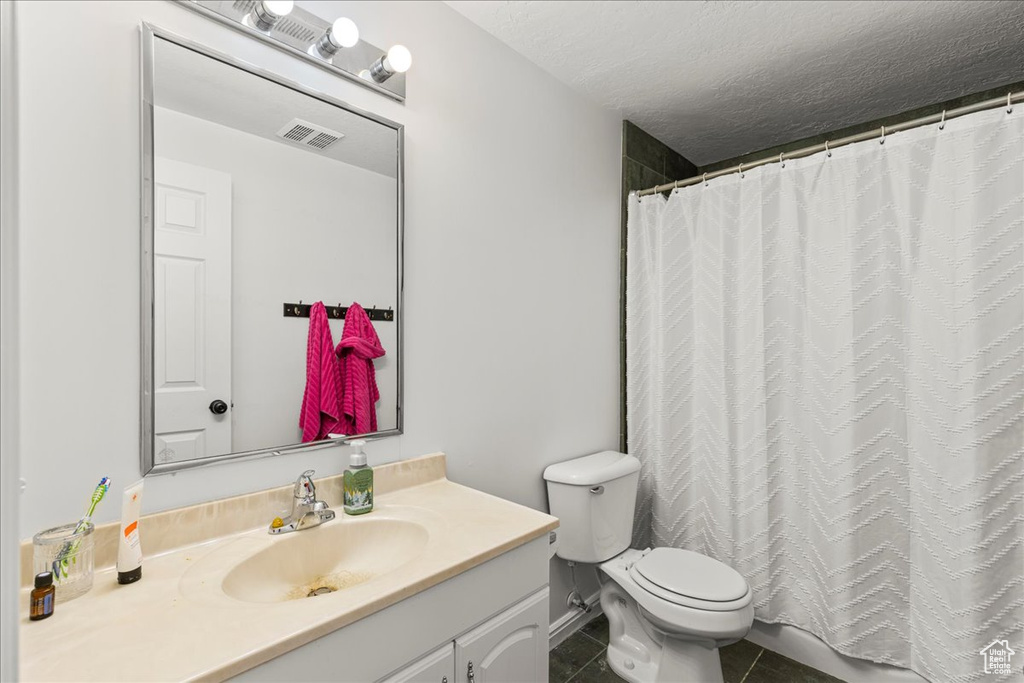 Bathroom featuring vanity, tile patterned flooring, a textured ceiling, and a shower with curtain