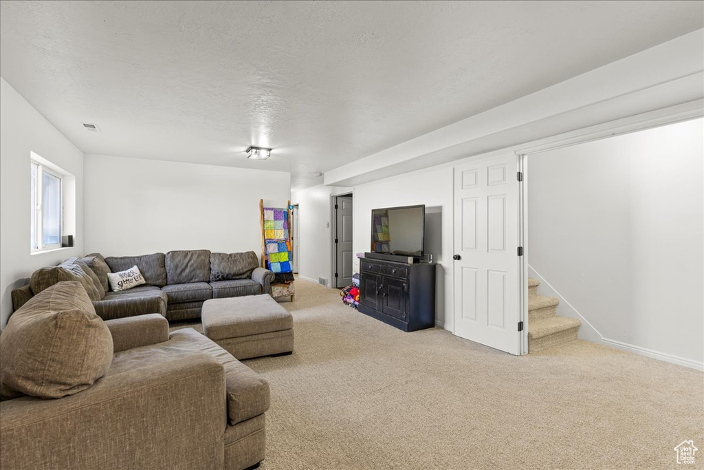 Living area with carpet flooring and stairway