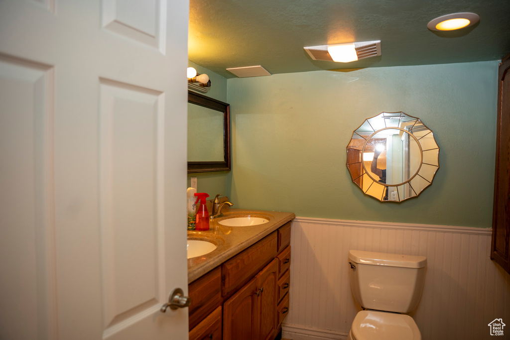 Bathroom featuring wainscoting and double vanity