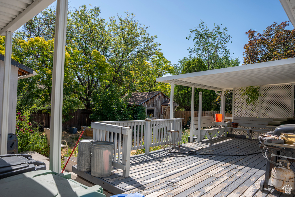 Wooden terrace with a fenced backyard and an outdoor structure