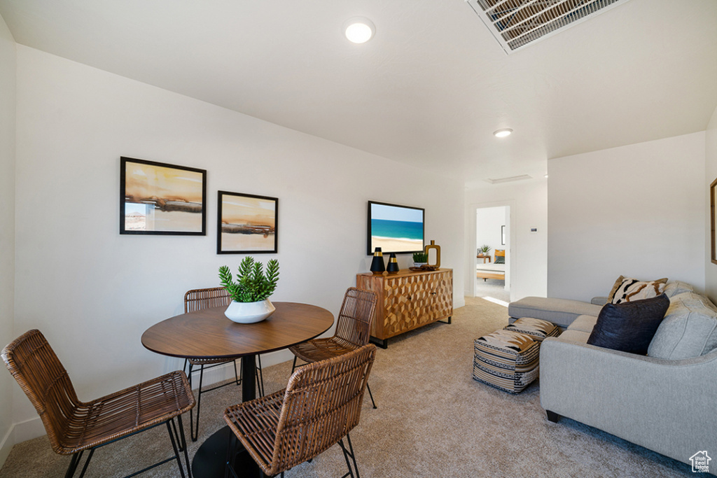 Dining room featuring light colored carpet and recessed lighting