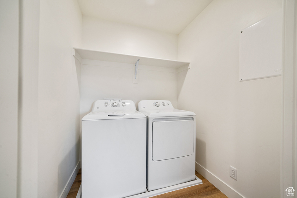 Laundry area with independent washer and dryer and wood finished floors