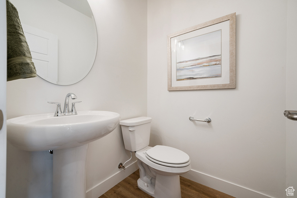 Half bath featuring baseboards and wood finished floors