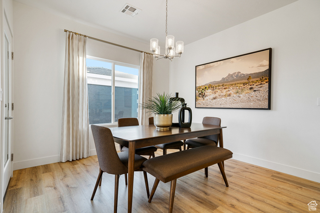Dining area with a chandelier and light wood-type flooring