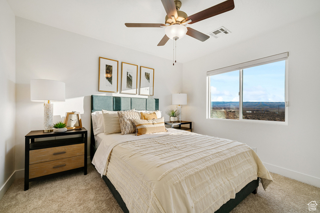 Bedroom with light carpet and a ceiling fan