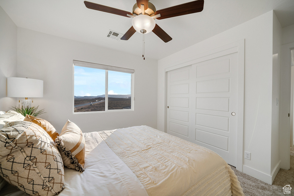 Carpeted bedroom featuring a closet and a ceiling fan